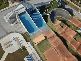 An aerial view of a newly constructed pump track surrounded by enthusiastic cyclists and families.