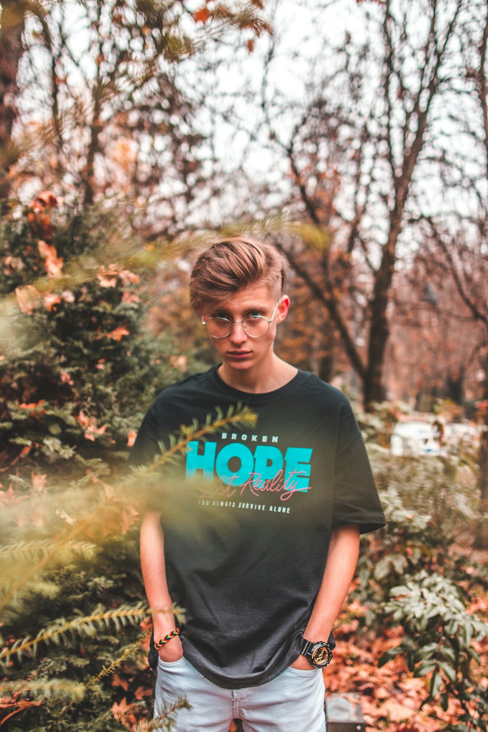 selective focus photography of man standing in front of tree