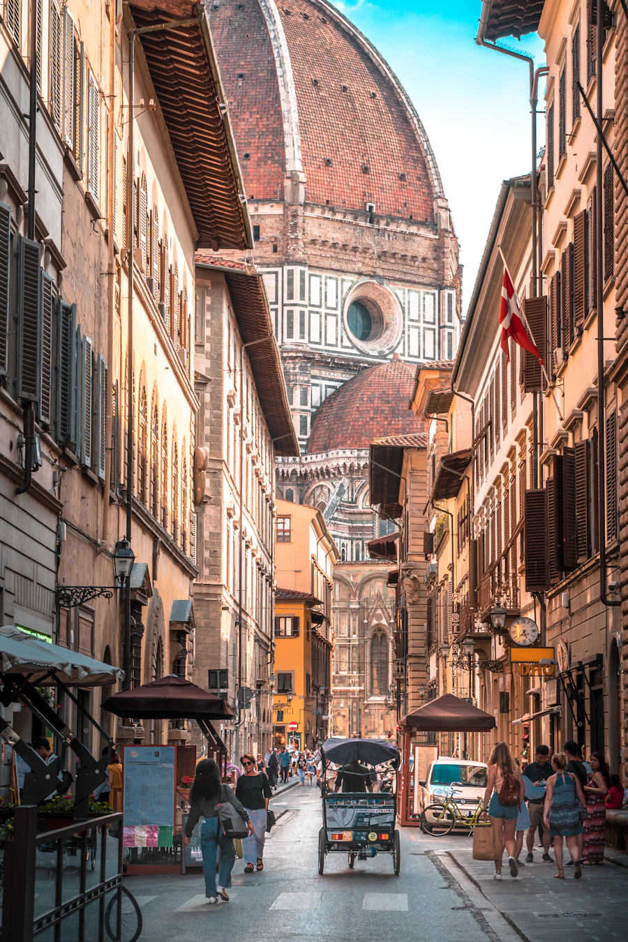 A narrow Florence street at dusk with the Duomo framed at the end
