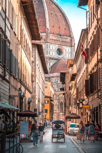 Rua de Florença com a cúpula do Duomo ao fundo e pedestres a caminho
