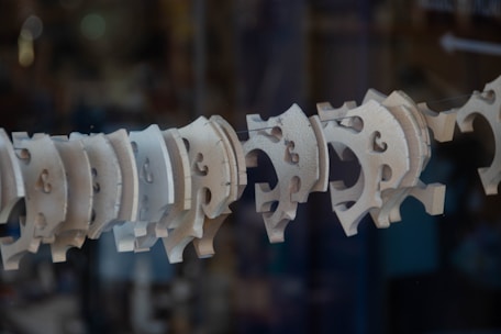 An array of intricately cut wooden and acrylic designs displayed on a workbench.