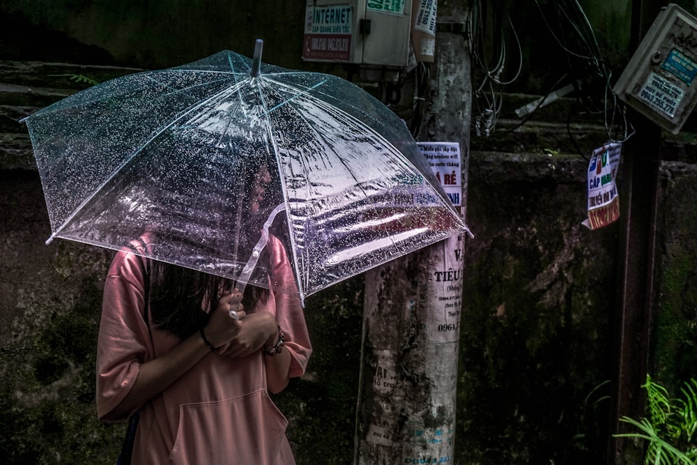 woman standing while holding clear umbrella