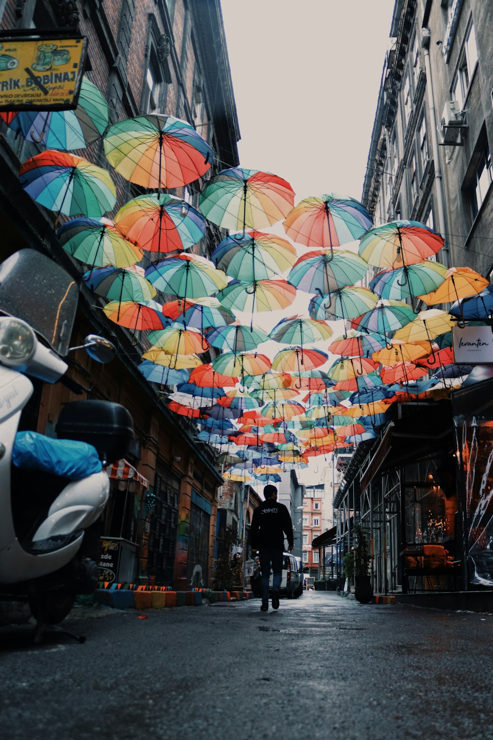 homem andando no beco do guarda-chuva flutuante