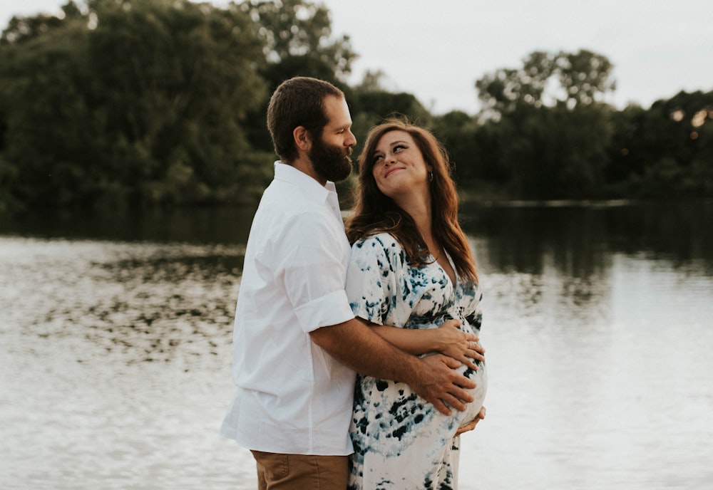 couple hugging each other near body of water