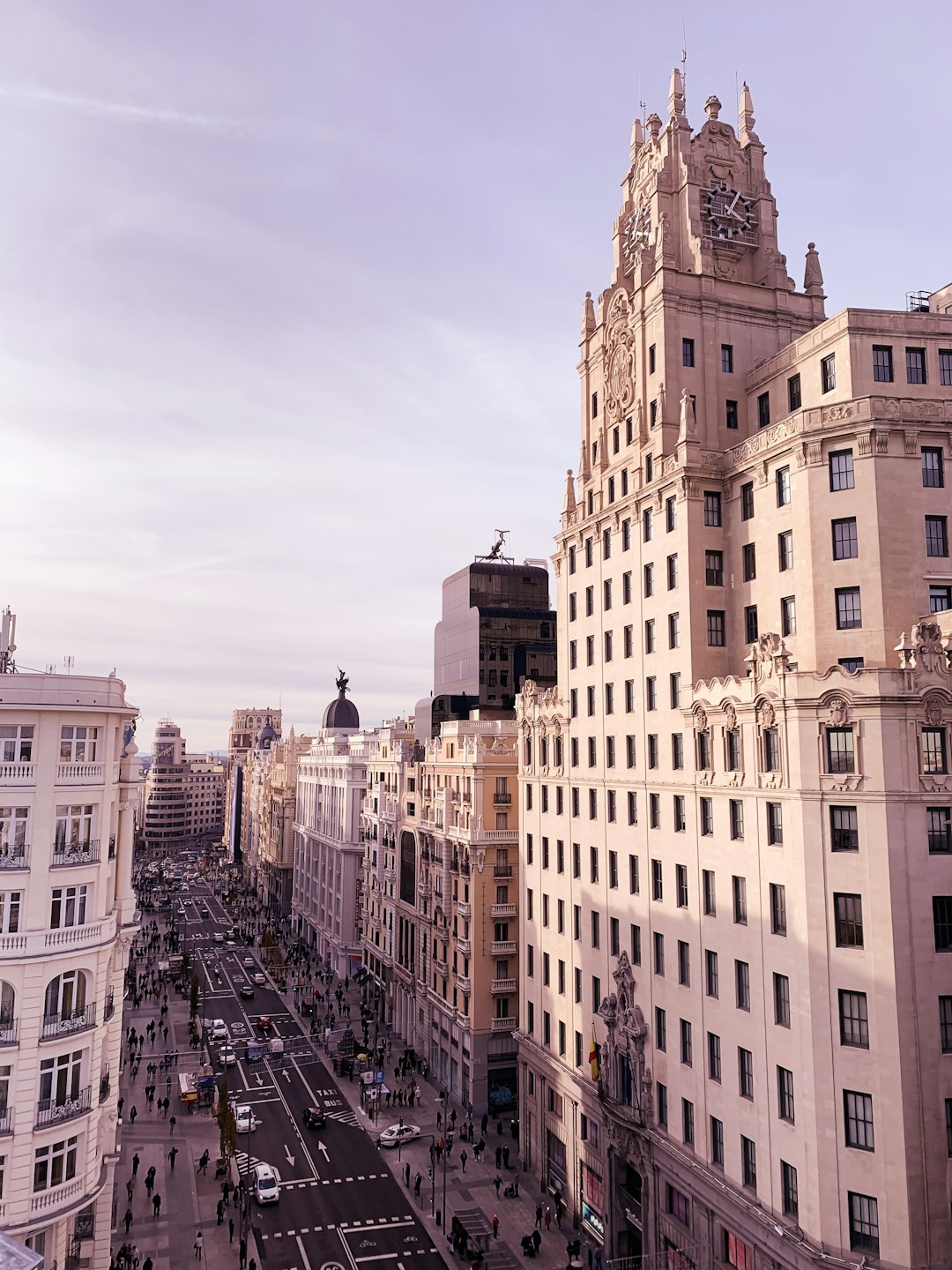 Madrid - The grand architecture of Madrid's Gran Via with its iconic stone facades and ornate detailing against a clear blue sky.
