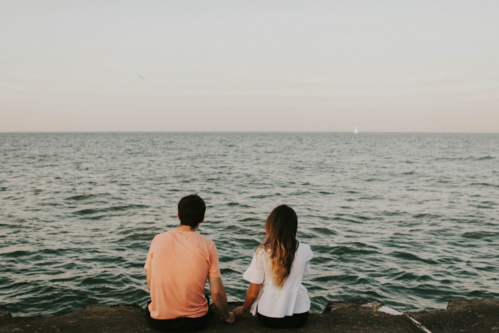 man and woman sitting while holding hands