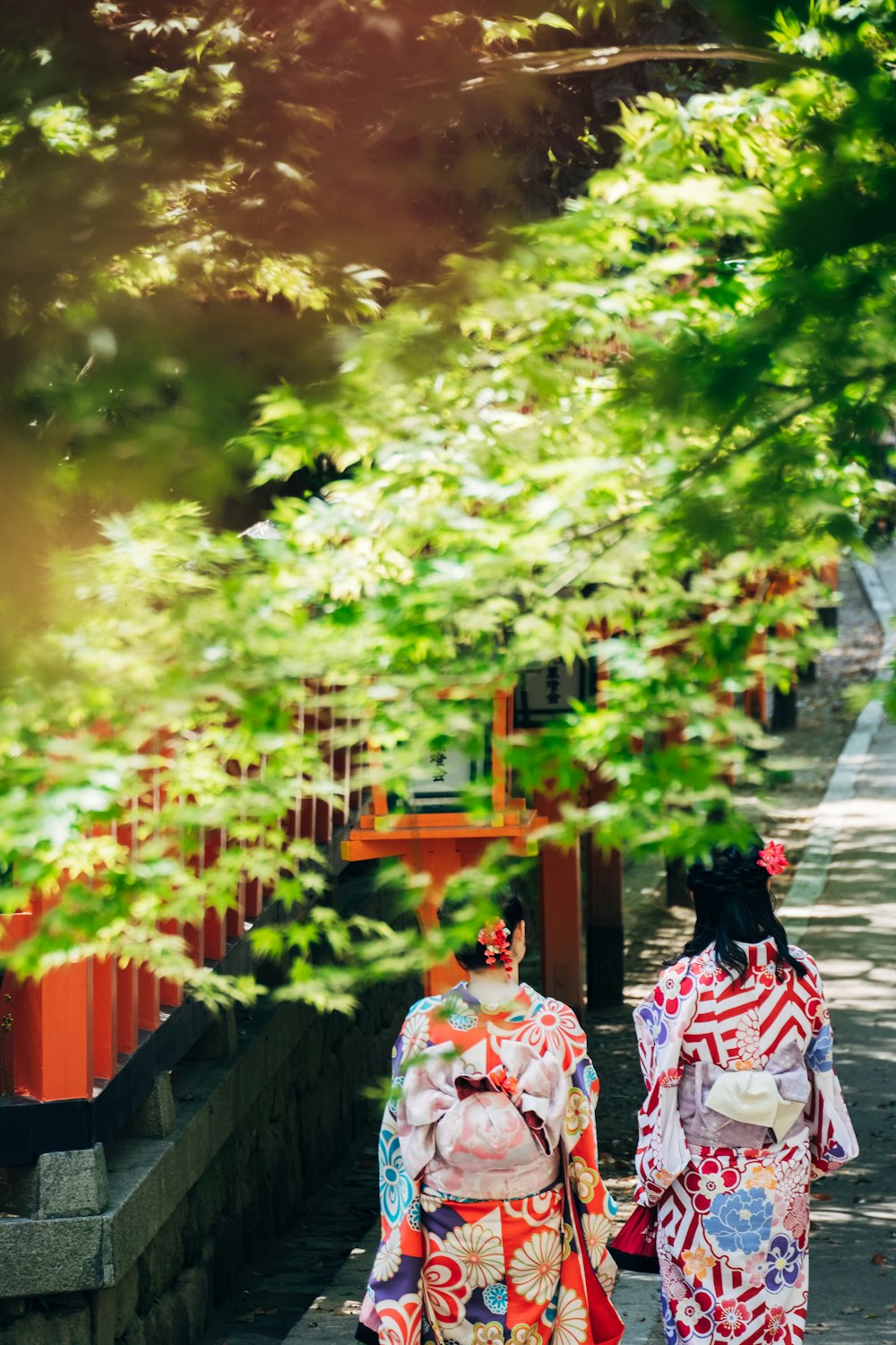 Dos geishas caminando sobre una pasarela de hormigón