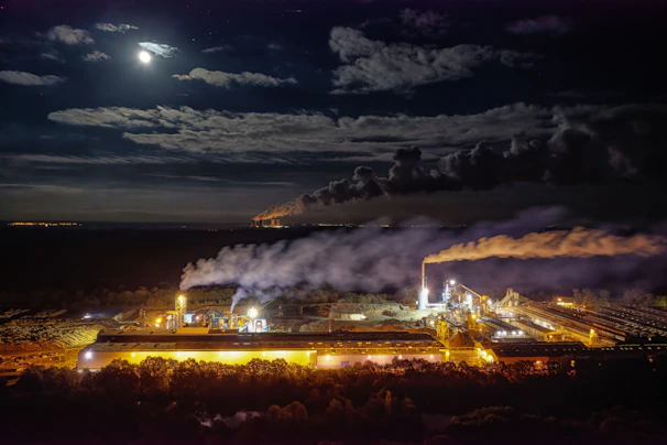 Nighttime view of factory lights with maintenance crew working under bright spotlights