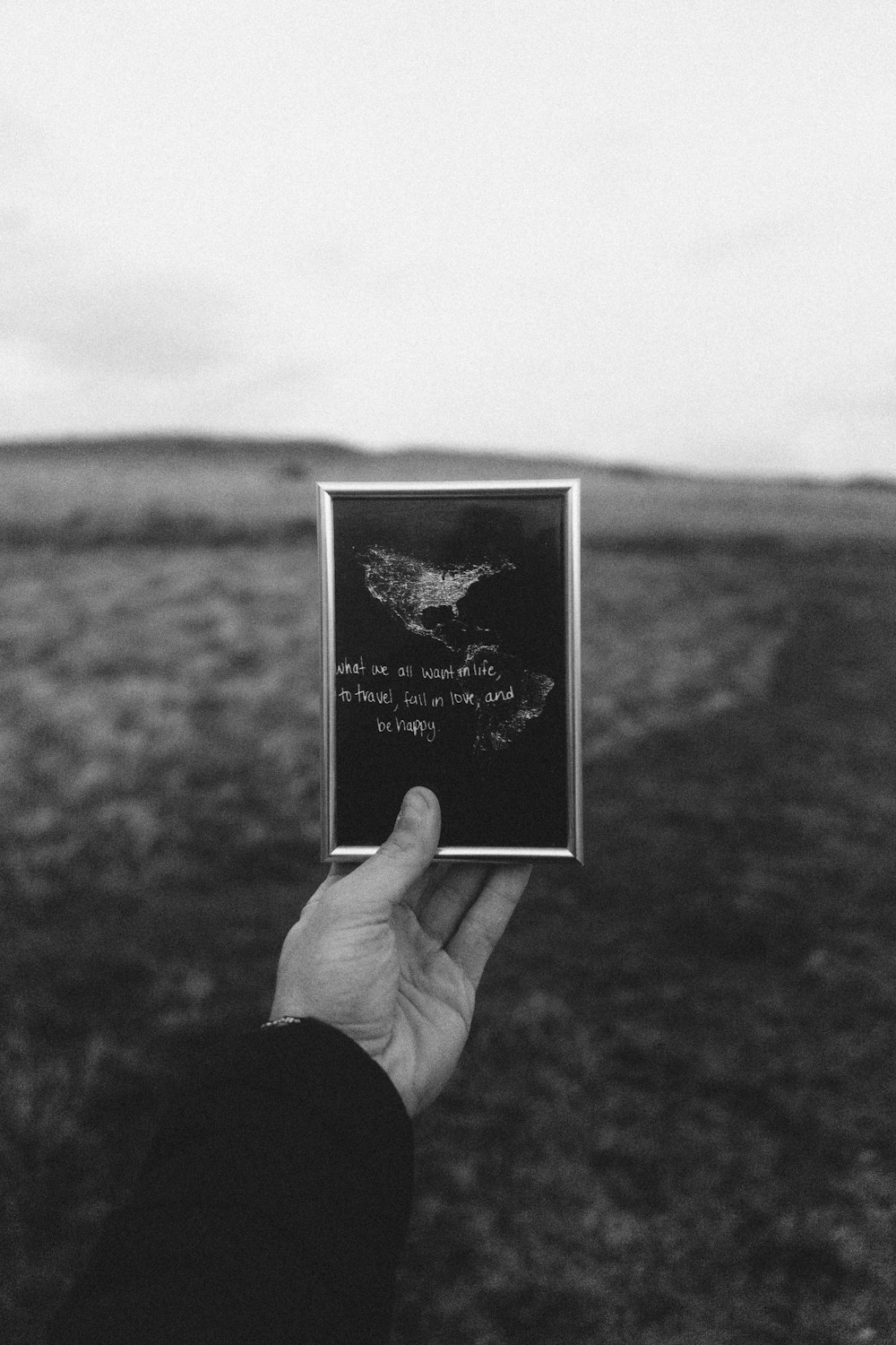 grayscale photo of person holding frame