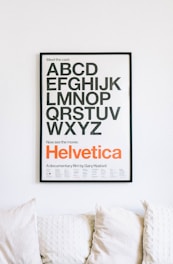 wall mounted Helvetica alphabet poster above sofa