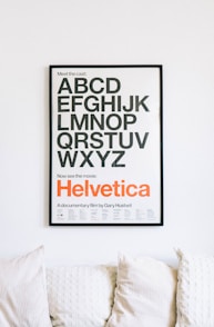 wall mounted Helvetica alphabet poster above sofa
