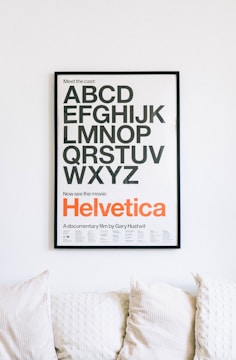 wall mounted Helvetica alphabet poster above sofa