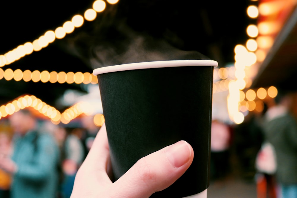 person holding black cup