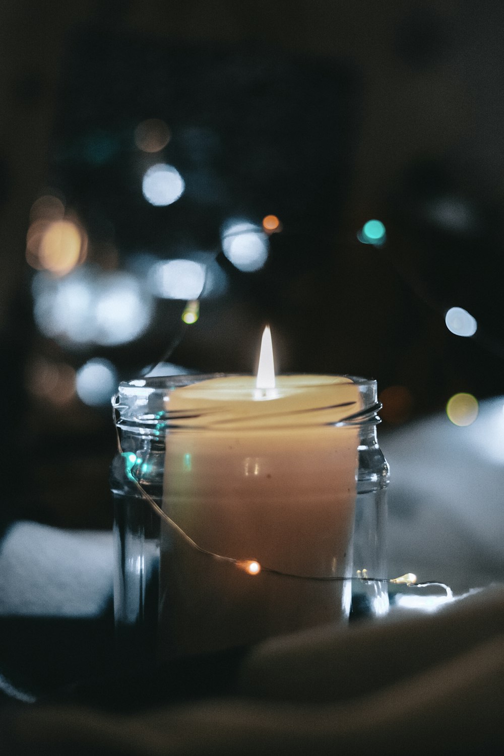 lighter white pillar candle inside glass jar