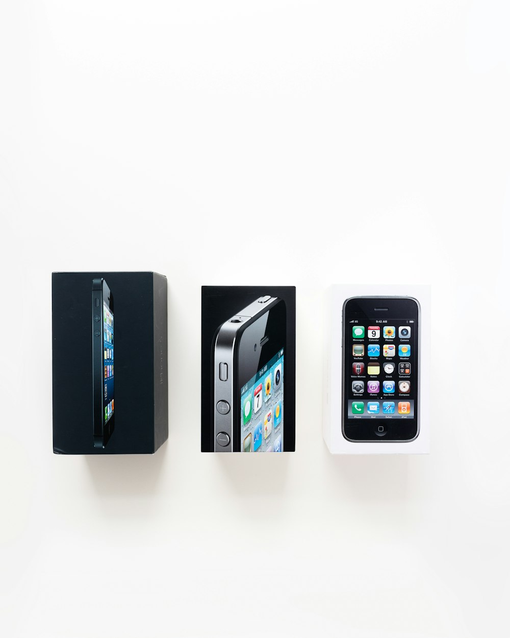 iPhone 3GS negro con caja sobre superficie blanca