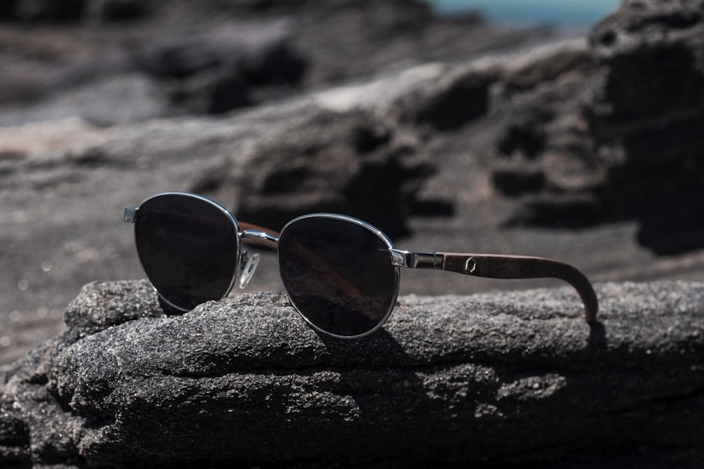black lens sunglasses on rock