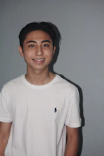 Young adult smiling confidently with traditional braces in a bright dental clinic.