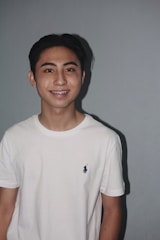 Young adult wearing braces smiling confidently in a modern dental office.