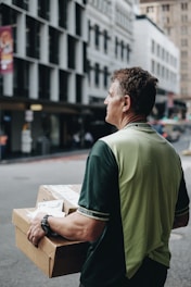 man carrying cardboard boxes during daytime