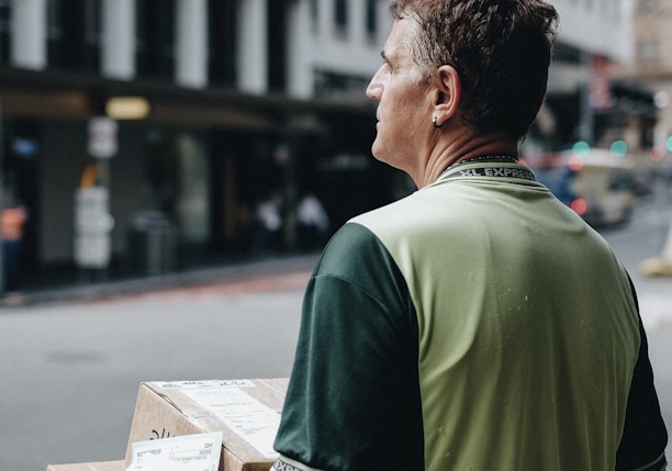 man carrying cardboard boxes during daytime