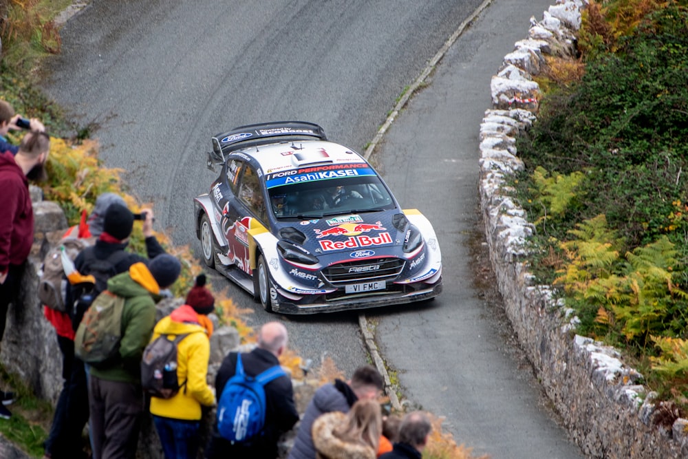 people watching passing race car