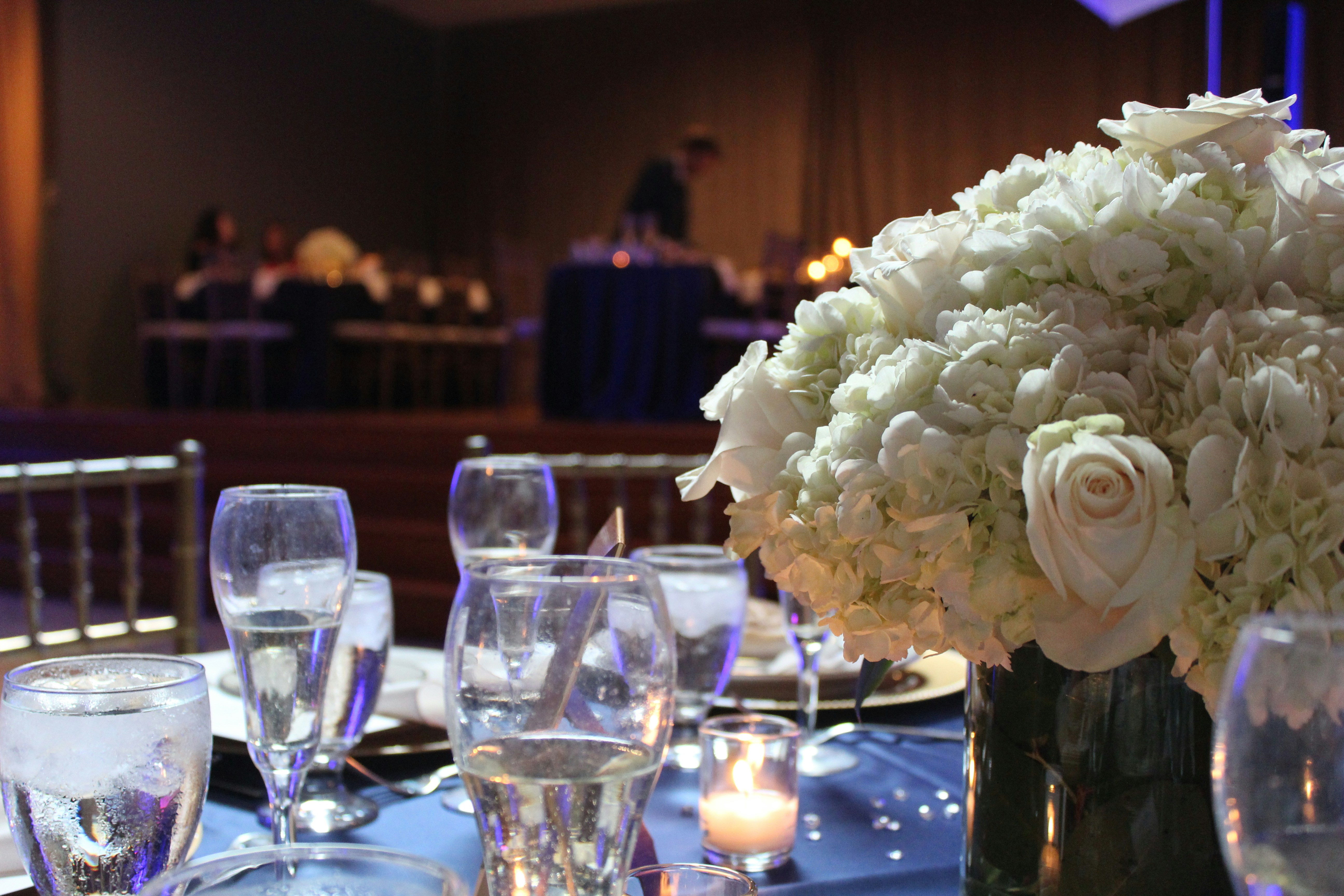 Table centerpiece with candles and white floral arrangement