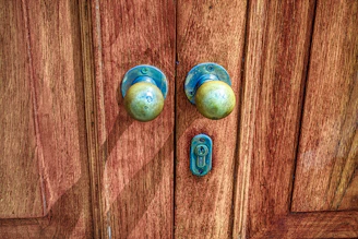 Close-up shot of a rustic bronze door knob gleaming softly against a wooden farmhouse door.