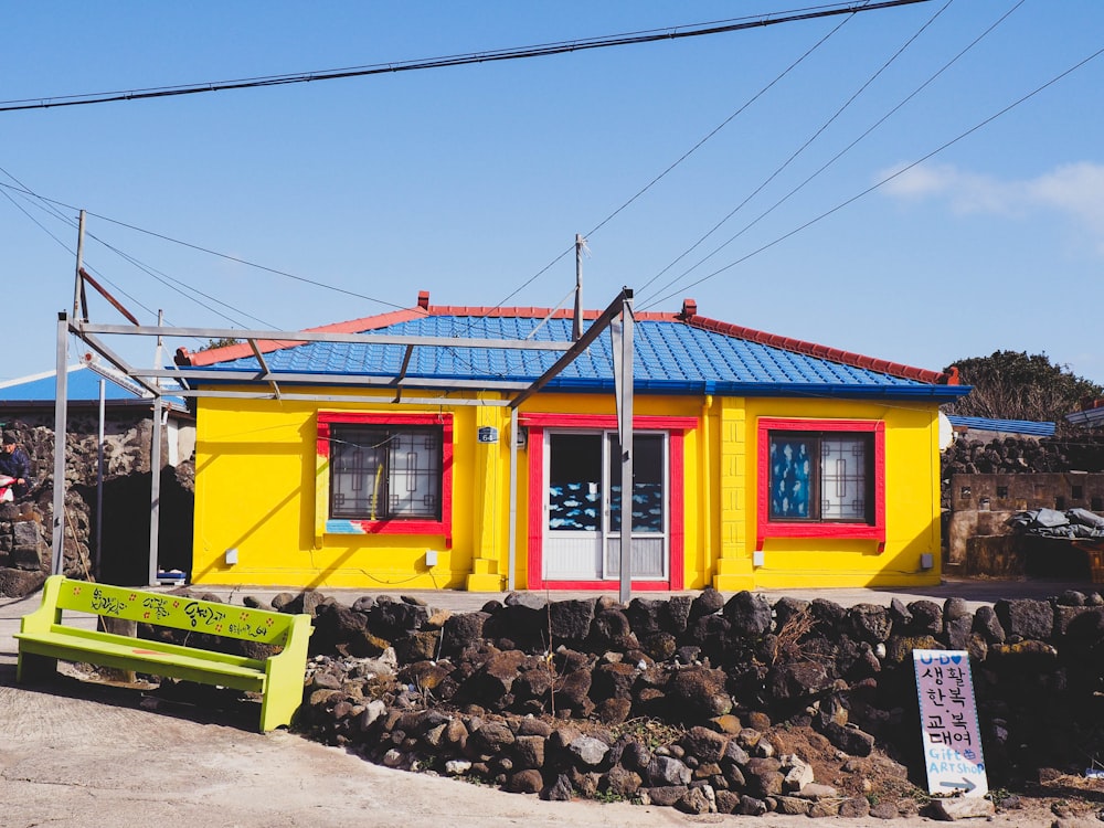 yellow painted house near bench