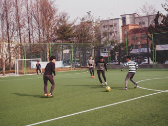 boys playing soccer on field