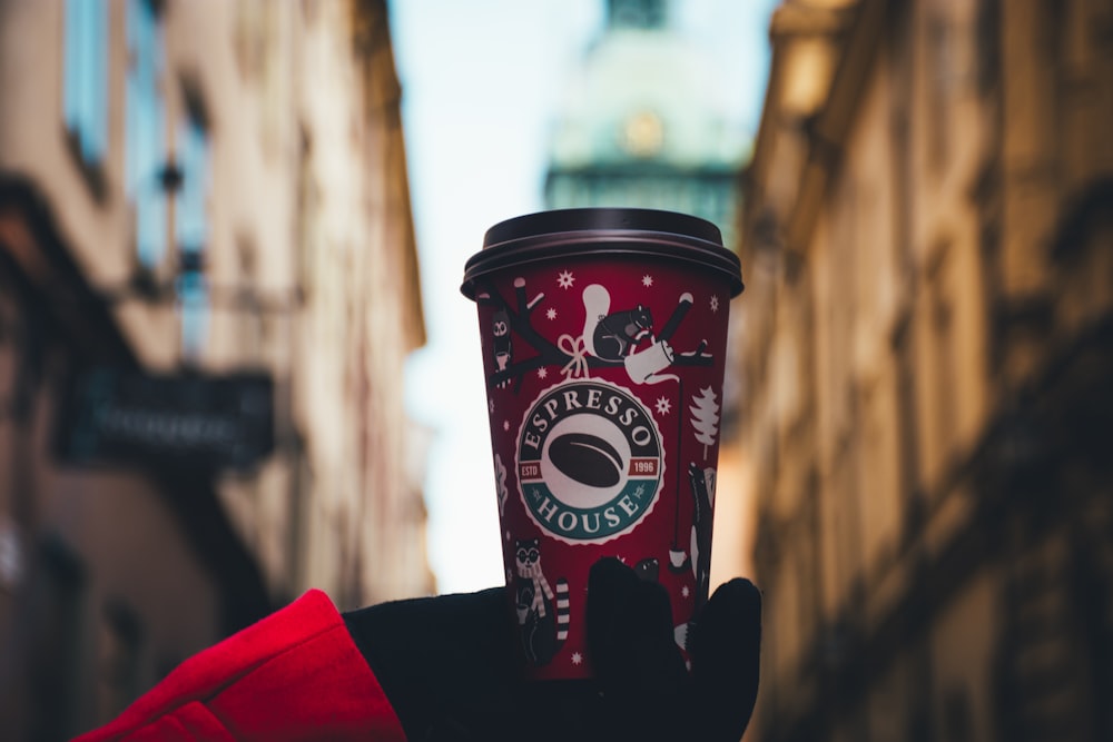 person holding red tumbler