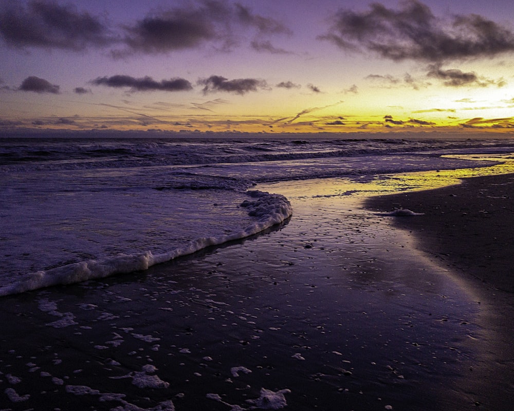 body of water under cloudy sky