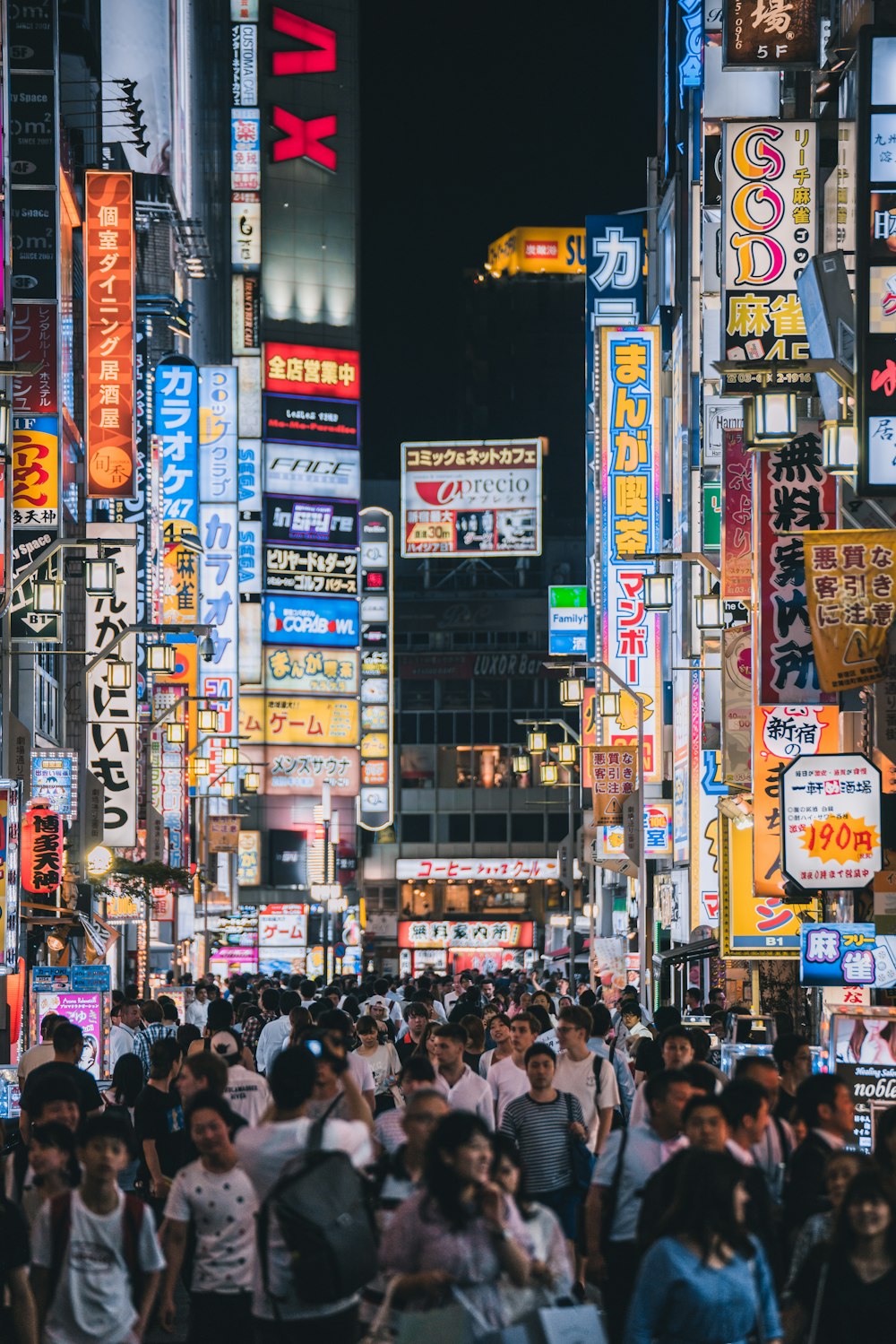 people walking under lighted billboards