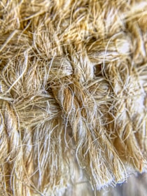 A close-up view of a textured, woven fiber material with tightly interwoven strands. The fibers appear soft yet robust, with a natural, earthy hue.