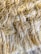 A close-up view of a textured, woven fiber material with tightly interwoven strands. The fibers appear soft yet robust, with a natural, earthy hue.