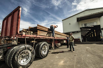 Delivery truck loaded with wooden beams ready to leave the yard.
