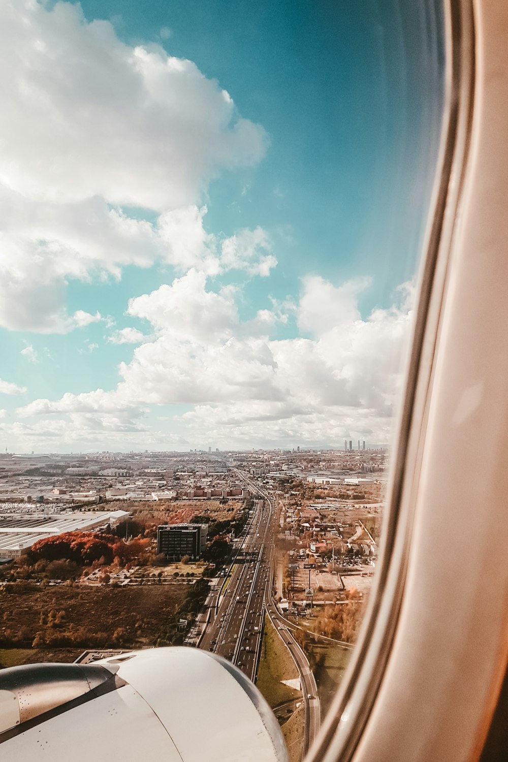 airplane window view of road and buildings during daytime