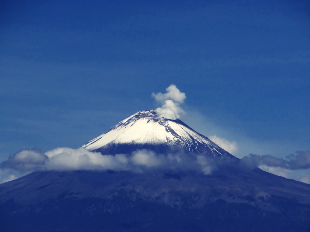 smokes on snow capped mountain during daytime