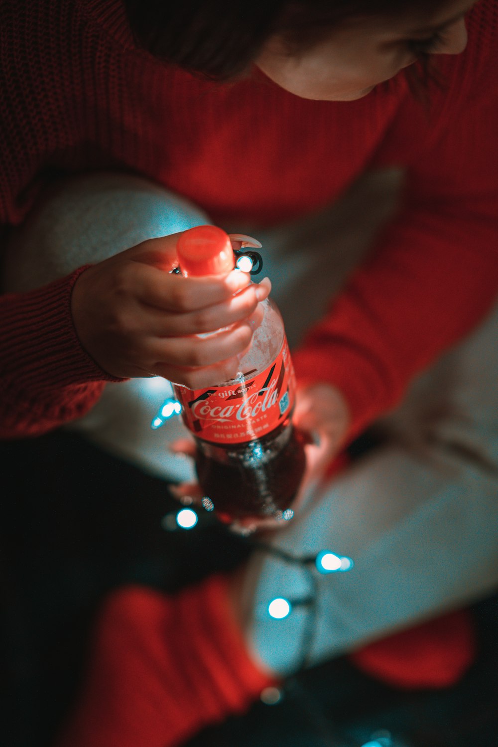 mujer sosteniendo una botella de Coca-Cola