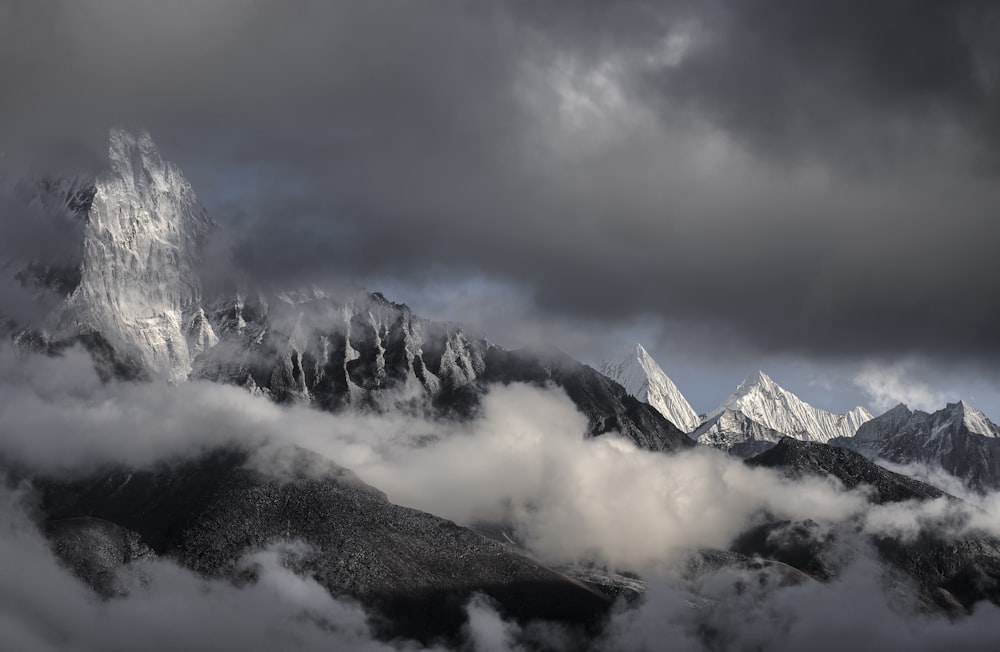 snowy mountain peaks under dark clouds