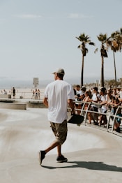 man in white shirt holding skateboard