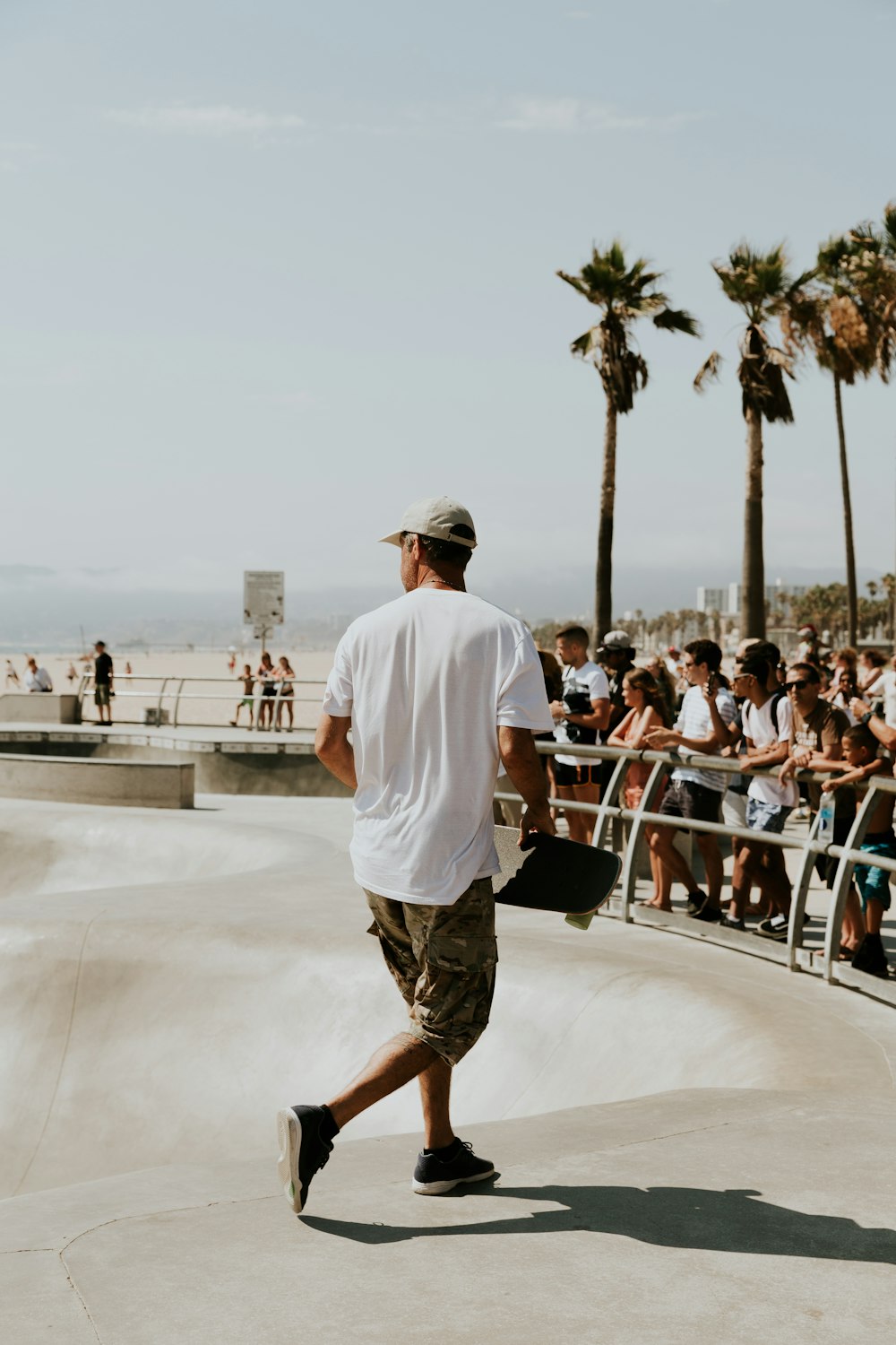 hombre con camisa blanca sosteniendo una patineta