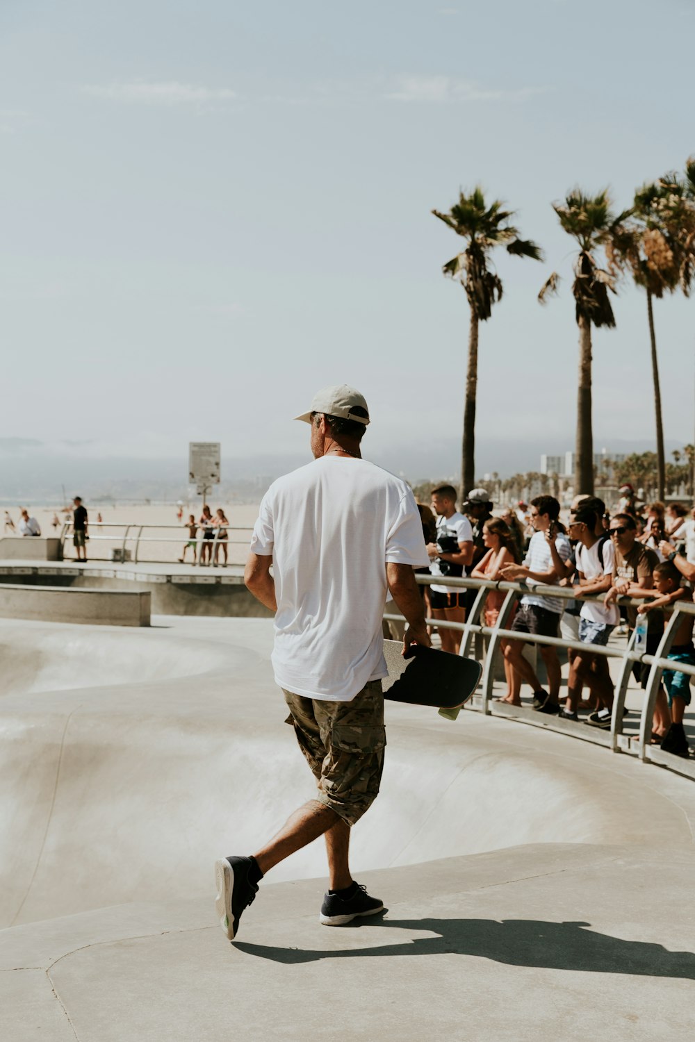 man in white shirt holding skateboard