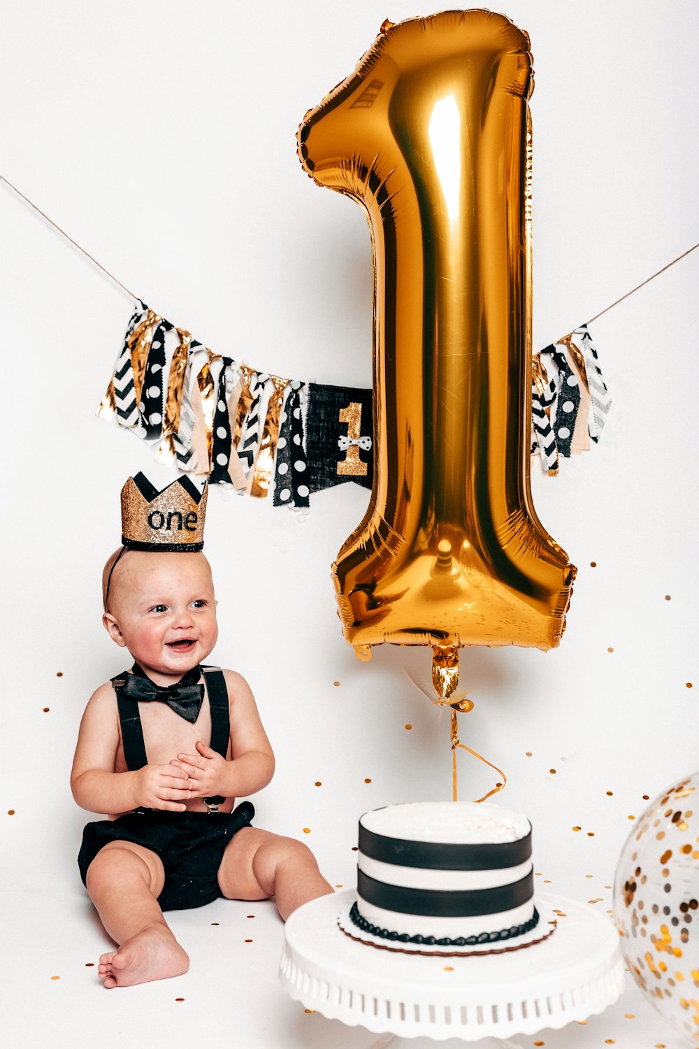 toddler sitting beside cake