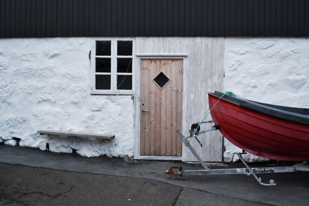 red and white boat on white concrete wall