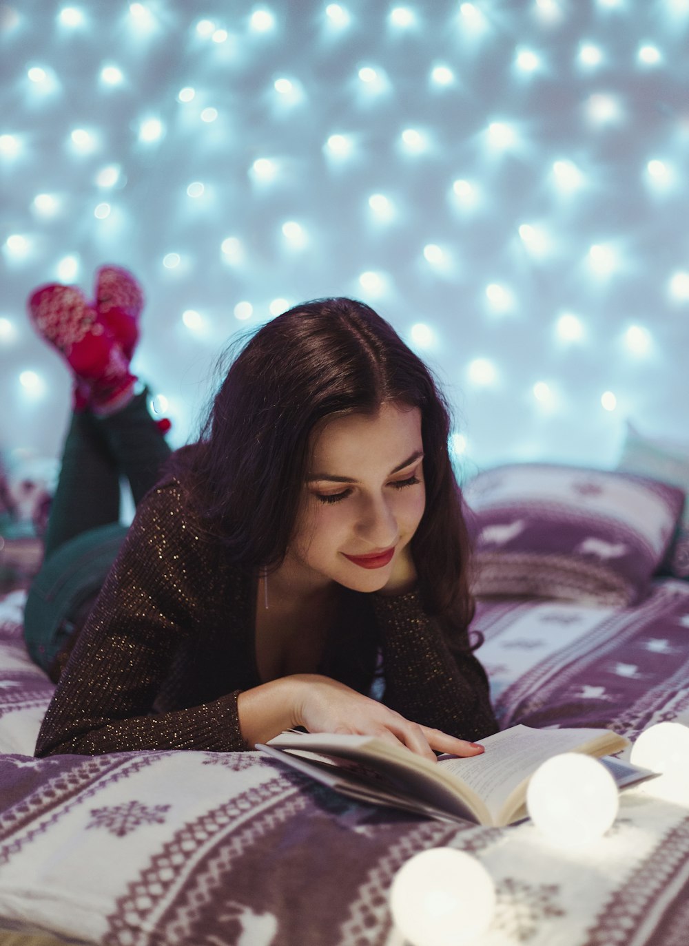woman in brown long sleeved shirt lying on bed and reading book