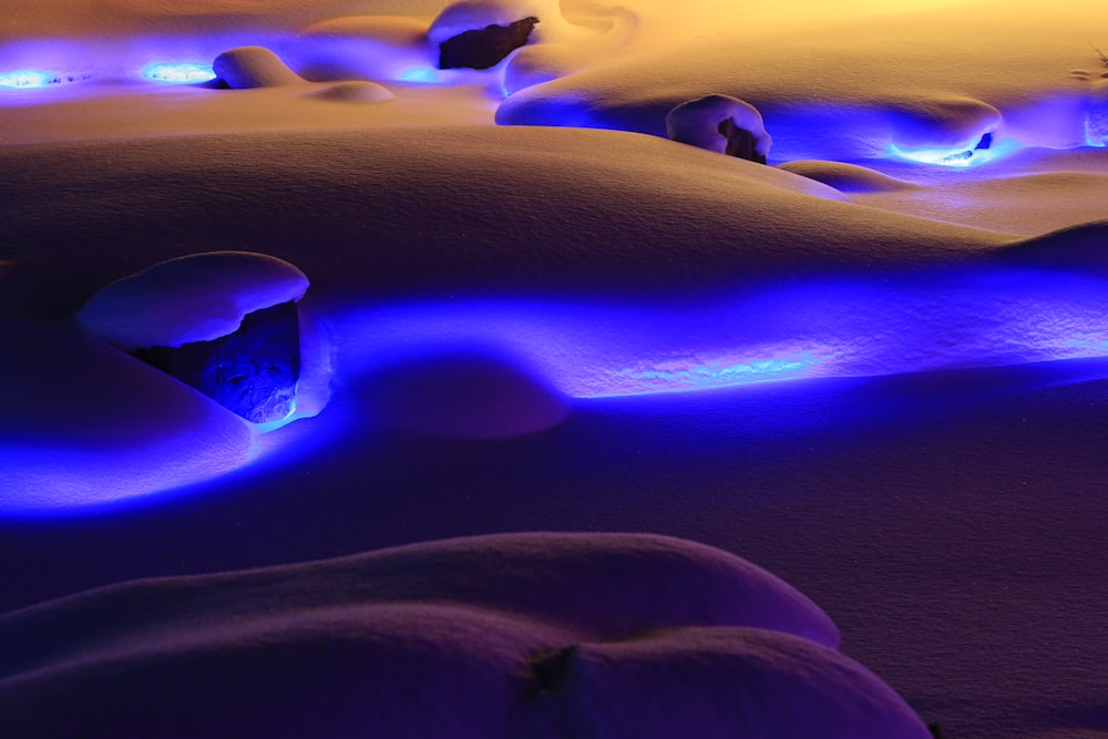 a snow covered ground with blue lights on it