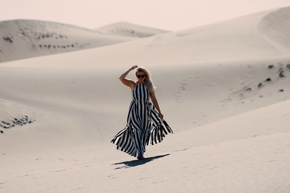 woman walking on dessert during daytime