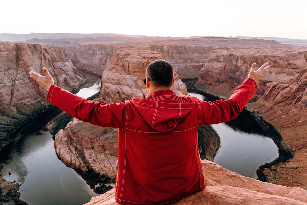 man sitting cliff overlooking Horseshoe, Grand Canyon