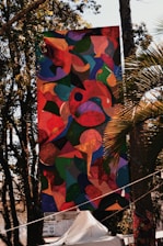 A colorful tarpaulin banner hanging outdoors with clear, sharp print