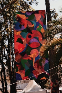 Close-up of a colorful custom banner hanging outdoors on a sunny day